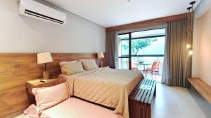 a bedroom with a bed and a chair and a window at Studio no Eco Resort Praia dos Carneiros - Serviços de Limpeza Diária in Tamandaré +14 photos