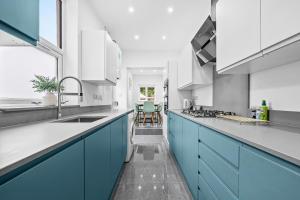a kitchen with blue cabinets and a sink at Coventry Arena Escape in Longford