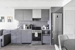 a kitchen with stainless steel appliances and a refrigerator at Bright 2BR Downtown Toronto Condo in Toronto