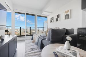 a living room with a couch and large windows at Bright 2BR Downtown Toronto Condo in Toronto