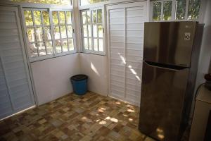 une cuisine avec un réfrigérateur en acier inoxydable et des fenêtres dans l'établissement Villa El Lago en Villas Camino Real cerca de las dunas de Chachalacas, à Ursulo Galván