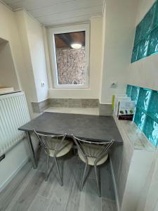 ein Esszimmer mit einem Tisch und zwei Stühlen in der Unterkunft LE COCON - Calme et Ressourcement in Rouffach