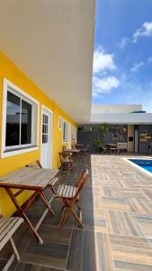 eine Terrasse mit Tischen und Stühlen neben einem Pool in der Unterkunft 700m da Praia de Atalaia com ar e piscina in Santa Maria + 34 Fotos