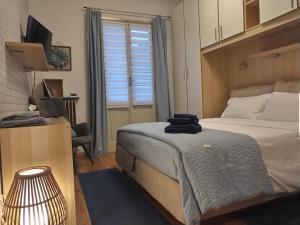 a bedroom with a bed and a desk and a television at Valtellina-La casetta di Elena in Sondrio