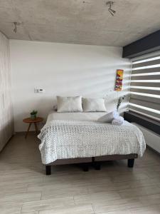 a bedroom with a bed in a white room at HOM Depto 4PAX con Parking En cerro Baron in Valparaíso
