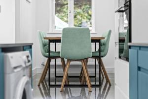 a dining room table with green chairs in a kitchen at Coventry Arena Escape in Longford