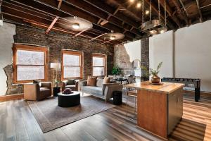 a living room filled with furniture and a brick wall at Soaring Designer Ceiling Condo near Market Square in Knoxville +18 photos