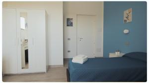 SestuにあるMhometredici Camera doppia Otelloの青い壁のベッドルーム(ベッド1台、鏡付)