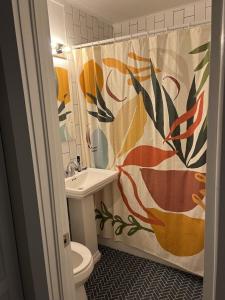 a bathroom with a sink and a toilet and a shower curtain at Eclectic Inn Downtown - 2 miles to Sanford Stadium in Athens