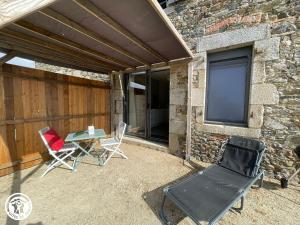 a patio with chairs and a table and a building at Charmant gîte rural proche du Puy du Fou - FR-1-426-593 in Les Essarts