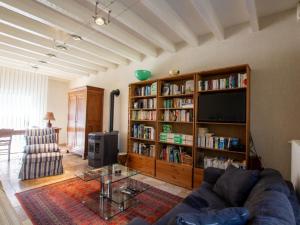 a living room with a couch and a book shelf at Maison avec Piscine Privée et Wifi en Dordogne - FR-1-616-501 in Maurens