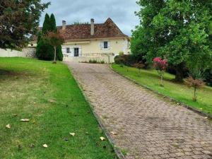 a cobblestone road in front of a house at Maison avec Piscine Privée et Wifi en Dordogne - FR-1-616-501 in Maurens