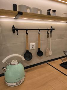 een groene theepot en keukengerei hangen aan de muur bij Simple Home in Kardítsa +27 foto's