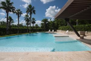 a swimming pool in a resort with palm trees at Casa Cielo 3 BR Penthouse with Views in La Romana