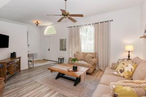 a living room with a couch and a table at Spacious Luxury Pool Home Oasis - 8mi to Airport in Palm Bay