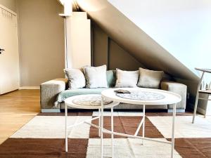 a living room with a couch and two tables at Refined and Ultra-Central Apartment Studio in Oslo