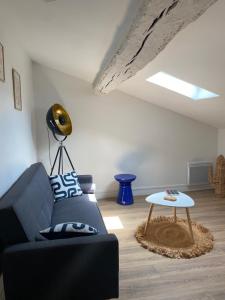 a living room with a blue couch and a table at Charmant T3 cosy à Mazamet in Mazamet