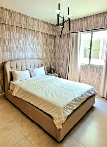 Ce lit se trouve dans une chambre dotée d'un mur en briques. dans l'établissement Residential Boca del Mar Tower III Apart 802, à Boca Chica