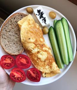 a plate of breakfast food with eggs bread and vegetables at Hotel Elite in Batumi
