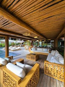 an outdoor patio with several couches and tables at Aketá Hotel Boutique in Trancoso