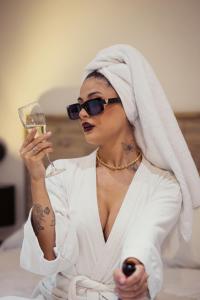 a woman in sunglasses holding a glass of wine at Hotel Sommelier Agustinas in Santiago
