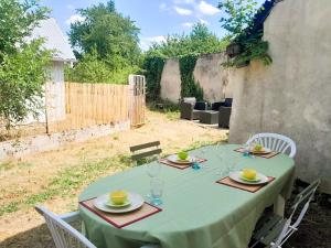 a table with a green table cloth on a table sidx sidx sidx at Cozy 2 bedroom house-garden-wifi Reuilly center in Reuilly