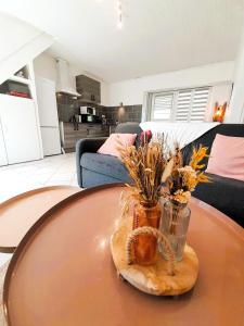 a table with a glass vase with flowers on it at Cozy 2 bedroom house-garden-wifi Reuilly center in Reuilly +11 photos