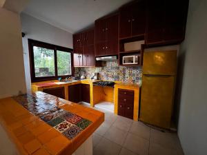 a kitchen with wooden cabinets and a table in it at Casa Manilkara Calakmul in Xpujil