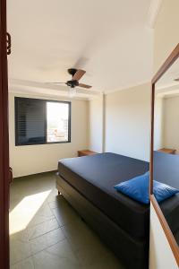 a bedroom with a bed and a ceiling fan at Apto com PISCINA 2 quadras da praia in Guarujá +7 photos