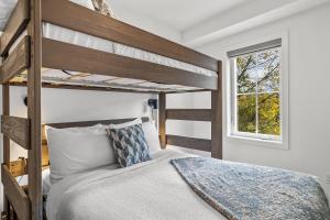 a bedroom with two bunk beds and a window at Golden Escape 2 Bdrm Mountain VIEWS - managed by Little Sister Getaways in Canmore