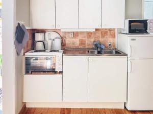 a white kitchen with white cabinets and a sink at 2 person holiday home in Ronneby-By Traum in Ronneby +25 photos