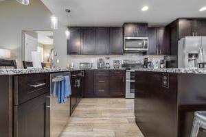 une grande cuisine avec des armoires et des appareils en bois dans l'établissement New king Beds Pool Hot Tub Outdoor Fireplace, à Lexington Place