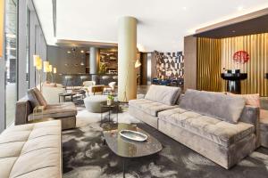 a living room with a couch and a table at NH Collection München Bavaria in Munich