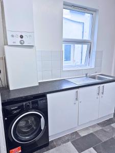 a kitchen with a washing machine and a sink at House for 4 in chatham with free driveway Parking in Chatham +11 photos