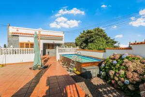 テロルにあるTeror Rural Retreat & Poolのスイミングプールと傘付きの家