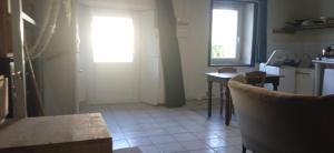 eine Küche mit einem Tisch und einem Fenster und einer Tür in der Unterkunft Argoat in Locarn