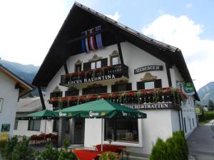 a building with a restaurant with umbrellas in front of it at Locus Malontina Hotel in Gmünd in Kärnten