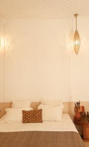 un lit avec des draps blancs et des oreillers dans une chambre dans l'établissement Riad Kahena, à Marrakech