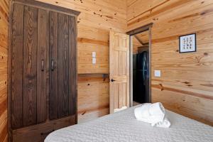 una camera da letto con un letto in una cabina di legno di All Tuckered Out - Riverfront Cabin, Fish, Hike & 5 Minutes to Sylva! a Sylva
