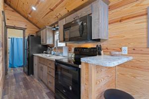 una cucina con piano cottura nero e forno a microonde di All Tuckered Out - Riverfront Cabin, Fish, Hike & 5 Minutes to Sylva! a Sylva