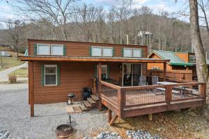 una grande casa con un grande ponte di fronte ad essa di All Tuckered Out - Riverfront Cabin, Fish, Hike & 5 Minutes to Sylva! a Sylva