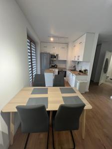 a kitchen and dining room with a table and chairs at Zakrzówek Apartament z Jacuzzi in Krakow