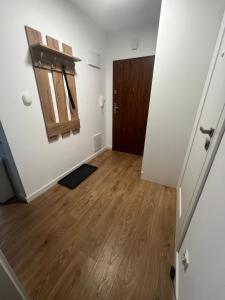 an empty room with a door and a wooden floor at Zakrzówek Apartament z Jacuzzi in Krakow