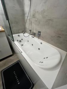 a bathroom with a bath tub and a sink at Zakrzówek Apartament z Jacuzzi in Krakow +8 photos