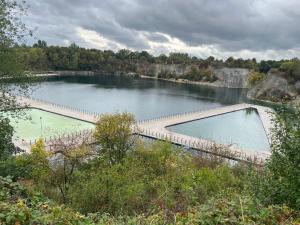 a large pool of water with a bridge over it at Zakrzówek Apartament z Jacuzzi in Krakow