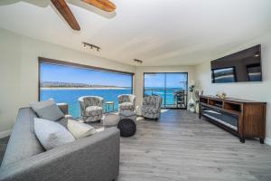 un salon avec un canapé, des chaises et une télévision dans l'établissement Ocean Vista Penthouse 1, à San Diego
