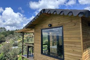 a house with a large window on the side of it at Glamping con jacuzzi cerca a Medellin in Guarne