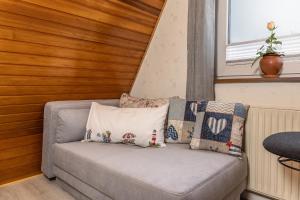 a couch with pillows on it in a room at Ferienwohnung KIEK RUT - am Deich in Wittmund