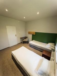 Un dormitorio con dos camas y una pared verde. en Hostel przy Żaglach, en Rybnik