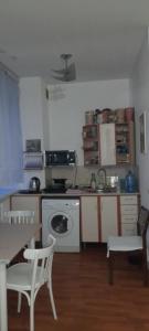 eine Küche mit einem Herd, einer Spüle und einem Tisch in der Unterkunft Petrovka in Dnipro + 13 Fotos